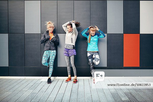 Drei Läuferinnen  die ihre Haare in der Stadtunterführung aufhängen.