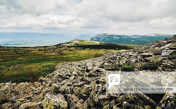 Rear view of woman hiking alone in rugged landscape  Ural Mountains  Russia