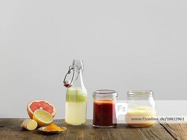 Fruchtsmoothies in Glasflaschen und Gläsern,  weißer Hintergrund