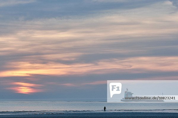 Schiff und zwei Personen am Crosby Strand bei Sonnenuntergang  Merseyside  England