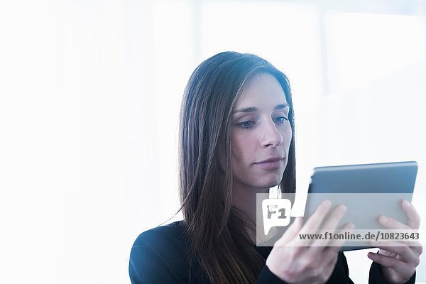 Kopf und Schultern einer jungen Frau mit digitalem Tablett