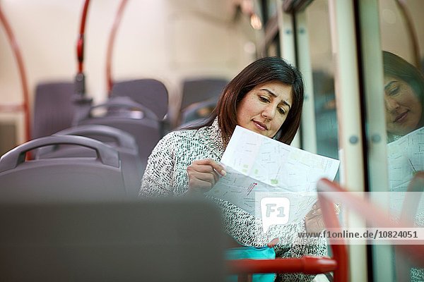 Reife Frau im Bus sitzend  Brief lesend
