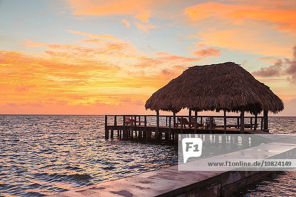 Stelzenpier und Reetdach bei Sonnenuntergang  St. Georges Caye  Belize  Mittelamerika