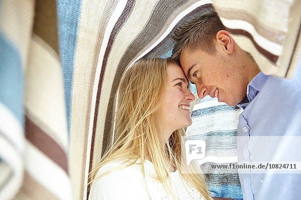 Romantisches junges Paar mit einer Decke bedeckt