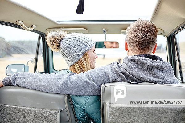 Rear view of young couple in car at beach