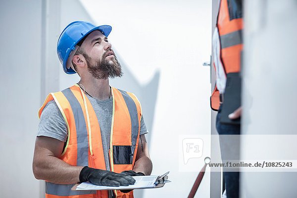 Construction worker talking to foreman from doorway of cabin on construction site