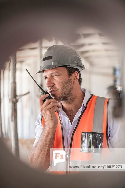 Site manager using walkie talkie on construction site