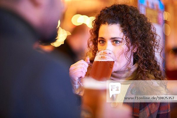 Junge Frau am Abend beim Bier trinken