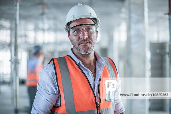 Portrait of mid adult male site manager on construction site