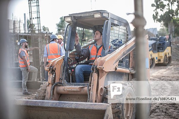 Construction worker driving excavator on construction site