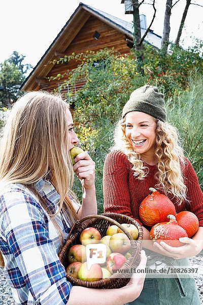 Zwei Freunde  die hausgemachte Produkte tragen  eine Frau  die Apfel isst.