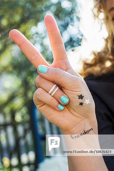 Frau macht Friedenszeichen mit der Hand