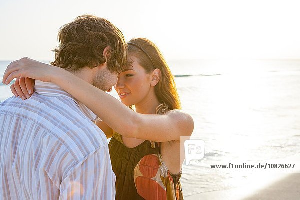 Romantic young couple face to face on sunlit beach  Majorca  Spain