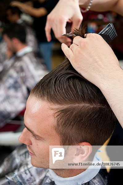 Hochwinkelansicht eines jungen Mannes im Friseursalon mit Haarschnitt