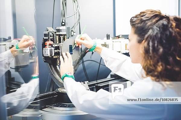 Wissenschaftlerin positioniert Dünnschichtprobe auf Probenhalter auf Röntgendiffraktometer