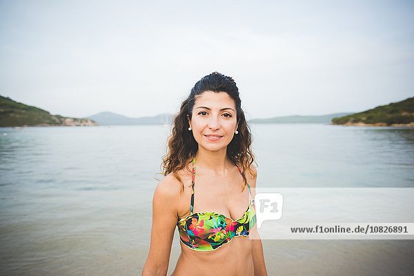 Woman wearing bikini top  sea in background