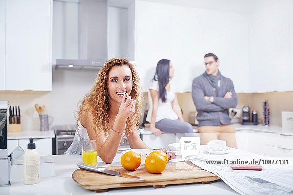 Porträt einer jungen Frau beim Frühstückscerealienessen an der Küchentheke