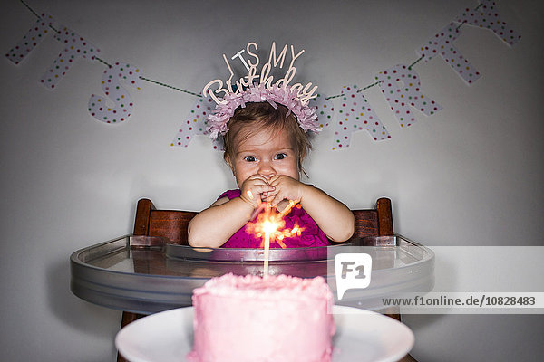 Kaukasisches kleines Mädchen bewundert Geburtstagstörtchen