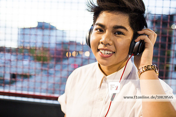 Asiatische Frau hört im Freien Kopfhörer