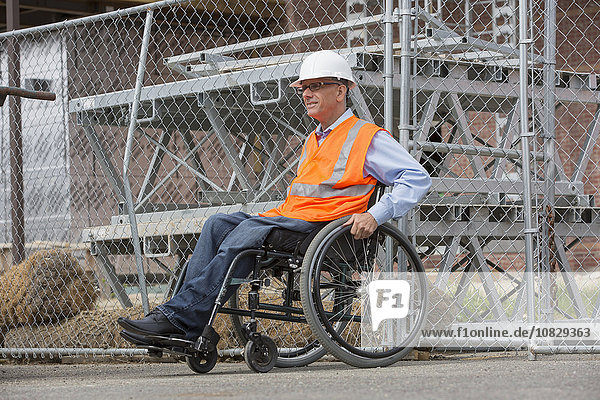 Kaukasischer Ingenieur im Rollstuhl auf einer Baustelle