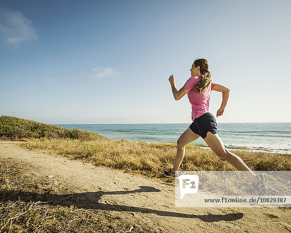 Kaukasische Frau joggt am Strand