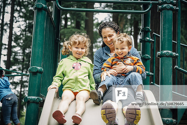 Caucasian mother and children playing on playground