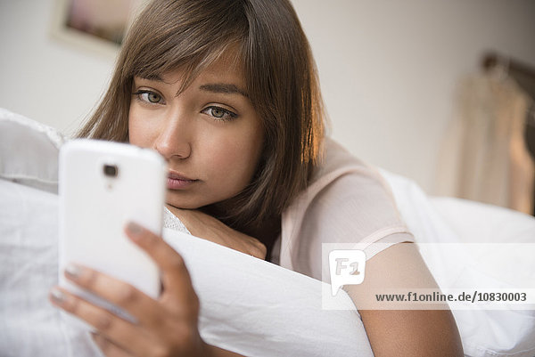 Mixed race woman using cell phone