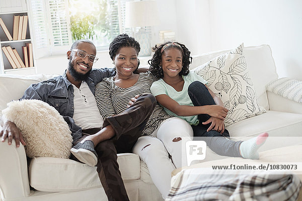 Black family smiling on sofa
