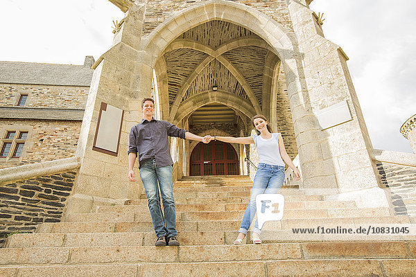 Caucasian couple standing on castle steps