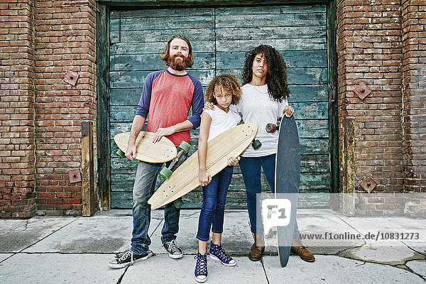 Familie hält Skateboards auf dem Bürgersteig