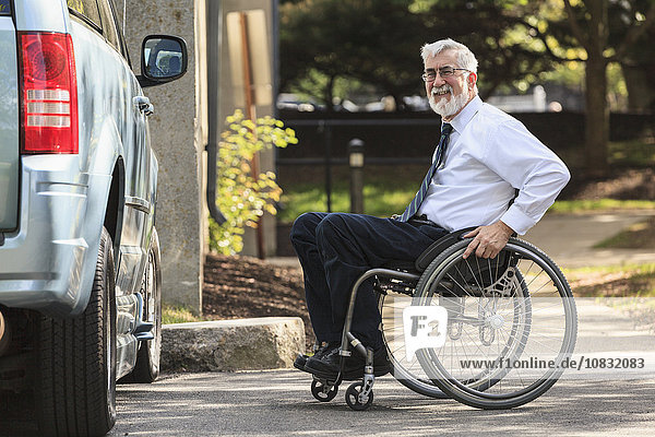 Caucasian businessman in wheelchair at van