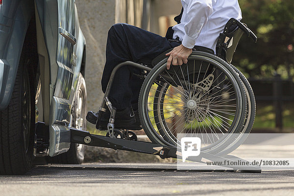 Caucasian businessman in wheelchair entering van