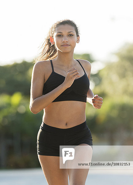 Mixed race teenage girl running outdoors