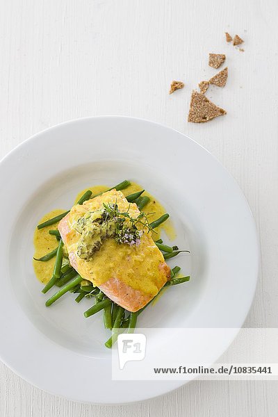 Salmon fillets with black morel mushrooms and curry sauce on green beans