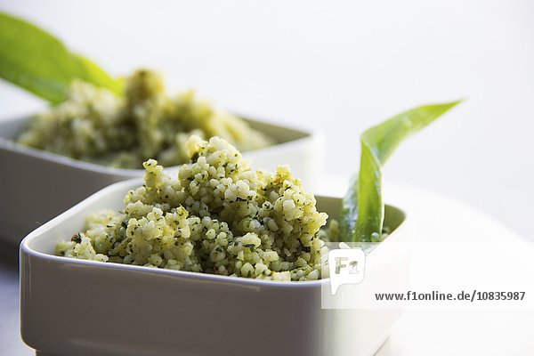 Weißes Quinoa als Salat mit Kräutern in weißem Schälchen