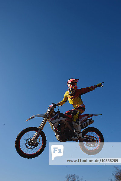 Motocross biker jumping over dirt track