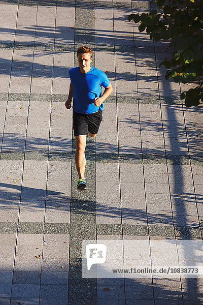 Young Caucasian man running in metropolitan area