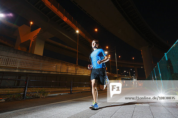 Young Caucasian man running in metropolitan area