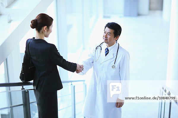 Japanese senior doctor with businesswoman at the hospital