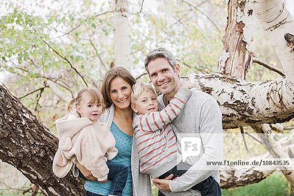 Portrait lächelnde Familie vor dem Baum