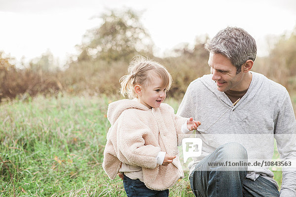 Father and toddler daughter in autumn park