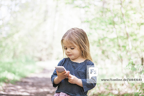 Kleinkind Mädchen mit Handy im Park