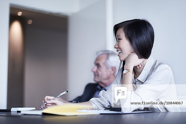 Smiling businesswoman taking notes in meeting