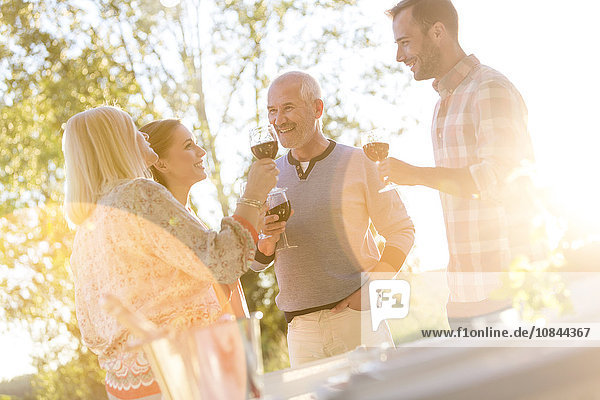 Seniorenpaar und erwachsene Kinder beim Weintrinken auf der Sonnenterrasse