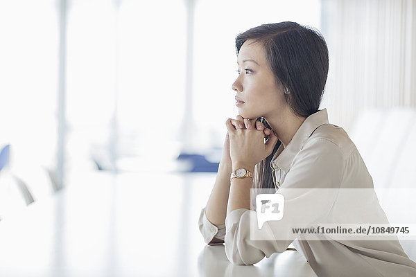 Pensive businesswoman looking away in conference room