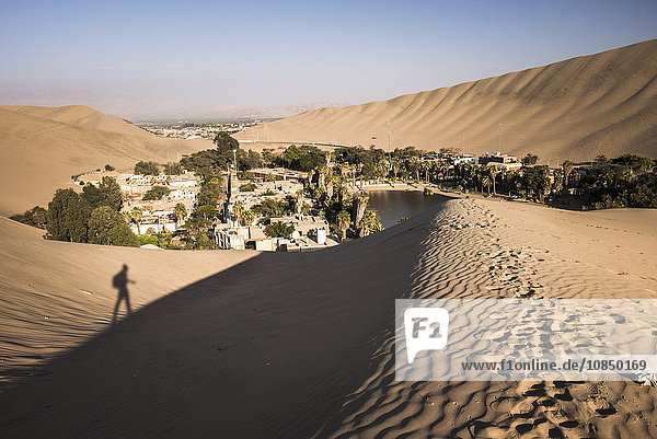 Climbing sand dunes at sunset at Huacachina  a village in the desert  Ica Region  Peru  South America