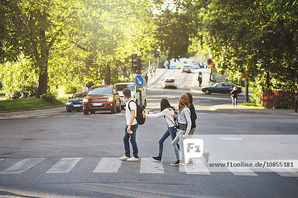 Side view of teenagers crossing road