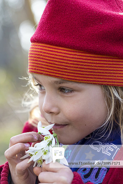 Mädchen mit Mütze riecht an Blume  Kiel  Deutschland  Europa