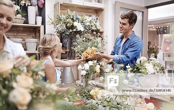 Florist schenkt Mann Blumenstrauß im Blumenladen