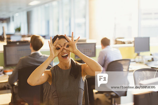 Porträt einer verspielten Geschäftsfrau die vorgibt im Büro eine Brille zu tragen.